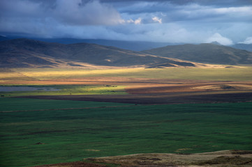 Storm sky and sun gaps on the fields