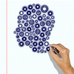 Head of gears drawn with a pen. Hand with a pen draws a head on a checkered paper
