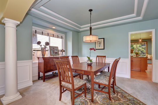 Dining room interior with mint walls and coffered ceiling.