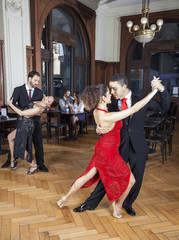 Passionate Dancers Performing Tango While Couple Dating In Resta