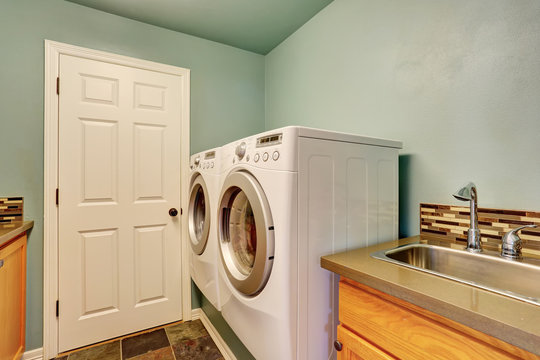 Mint laundry room with white appliances and sink