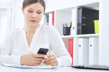 Attractive woman reading text message on cell telephone.