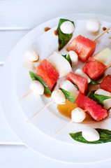 Watermelon kebab with spicy sauce, basil and mozzarella cheese