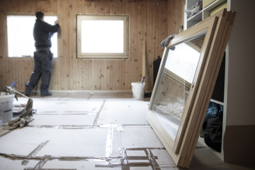 Worker installing new wooden windows - 117926074