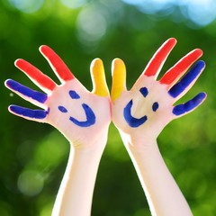 Adorable little girl with her hands painted having fun outdoors