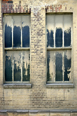 Stillgelegte Fabrik / Die verschmutzten Fenster einer stillgelegten Fabrik und Ruine.