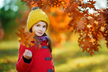 Cute little girl having fun on beautiful autumn day