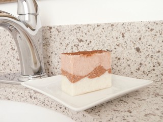Natural handmade pink soap on a white ceramic soap dish