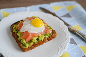 Sandwich with avocado, smoked salmon and quail egg