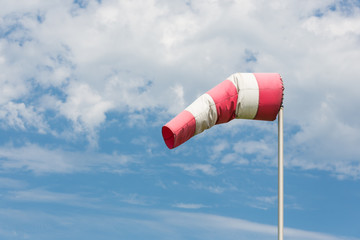 Windsock blowing in wind against cloudy sky