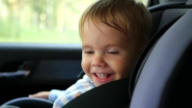 the child rides in the car and laughs