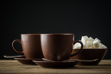 coffee cups, beans and sugar on rustic wooden table background
