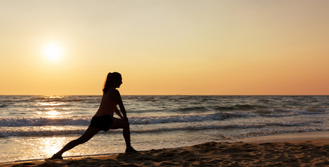 Stretching einer Frau am Strand bei Sonnenuntergang