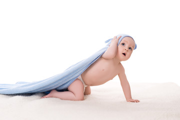 funny baby in blue cape with hood crawling and looking up with surprised, isolated on white