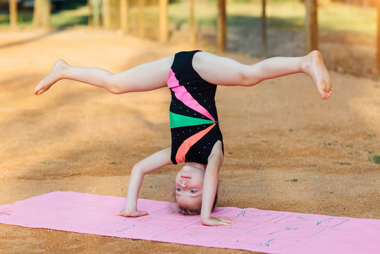 Girl performs gymnastic exercise in the fresh air