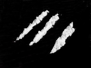Cocaine drug powder on black background