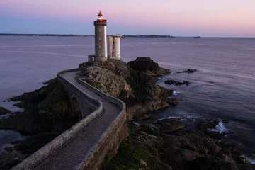 Wall murals Atlantic Ocean Road Lighthouse in the Atlantic ocean at dusk