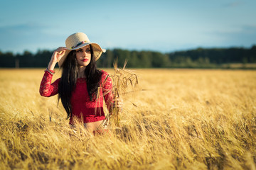 Summer portrait of young brunette woman in wheat field