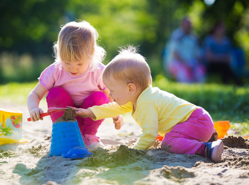 Two children playing in sandbox