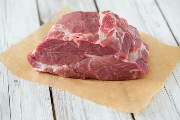 raw pork neck meat on wooden table