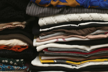 Pile of colourful clothes in a closet.