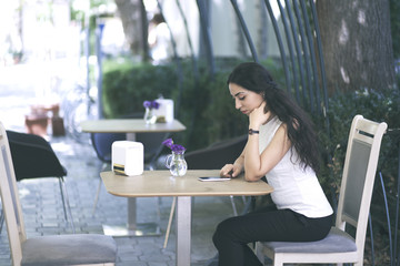 Woman holding  phone in a cafe