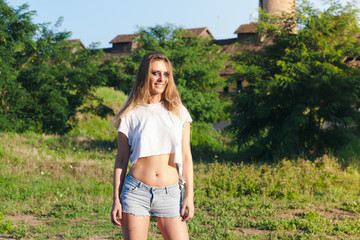 young woman in torn t shirt posing in nature