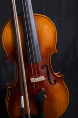 Fototapeta na wymiar Close up Violin Scroll and bow standing on black background