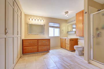 Large bright bathroom in beige color with tile floor