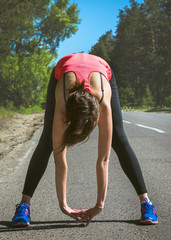 Young fitness woman runner stretching before run. Runner athlete