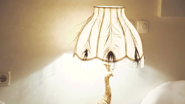 Image of golden chandelier- peahen on the nightstand