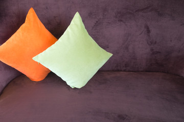 green and orange pillow on sofa