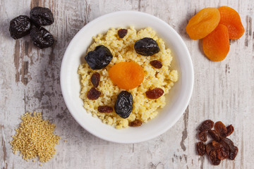 Cooked millet groats on white plate, healthy food and nutrition