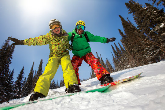 Young couple having fun with snowboards.