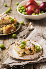 Light pie with fresh berries and fruit. Gooseberries and Apples Pie on a rustic wooden background and homespun cloth. Slice of pie 