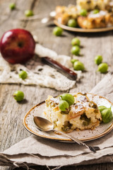 Light pie with fresh berries and fruit. Gooseberries and Apples Pie on a rustic wooden background and homespun cloth. Slice of pie 