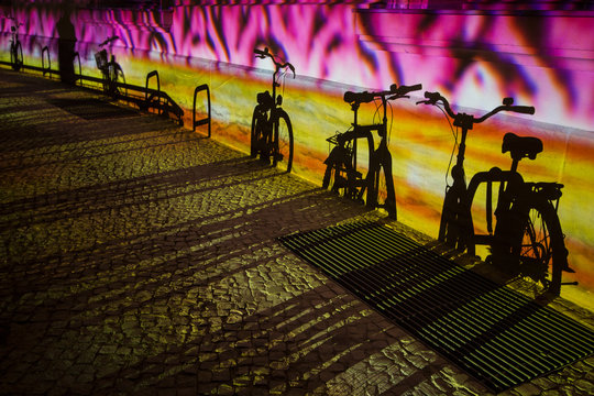 color illuminated wall with shadows of bicycles