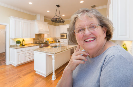 Happy Senior Woman In Custom Kitchen Interior