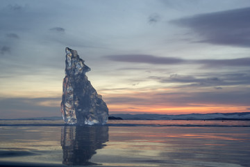 Fototapeta na wymiar A piece of ice lying on the frozen surface of lake Baikal at daw