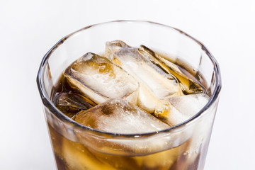 A glass of cold drink with ice on a white background