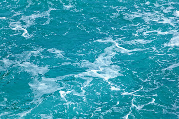 the surface of the turquoise sea water with foam. Natural backgr