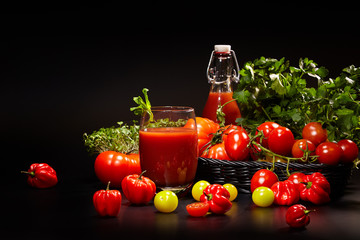 fresh organic tomatoes and tomato juice on black. the detox conc