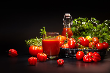 fresh organic tomatoes and tomato juice on black. the detox conc