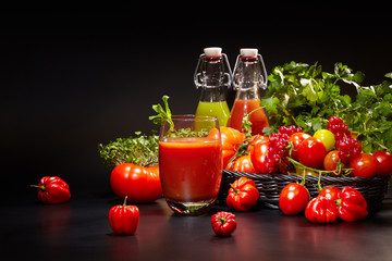 fresh organic tomatoes and tomato juice on black. the detox conc