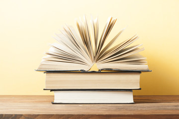 Open book, hardback books on wooden table. Education background. Back to school. Copy space for text.