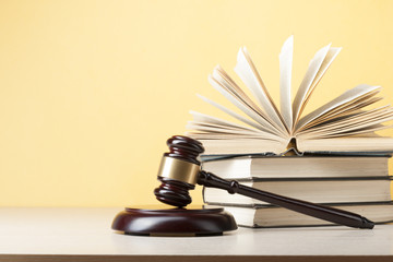 Law concept - Book with wooden judges gavel on table in a courtroom or enforcement office.