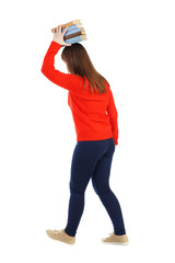 Girl comes with  stack of books. side view. Rear view people collection.  backside view of person.  Isolated over white background. The girl is holding a stack of books on his head.