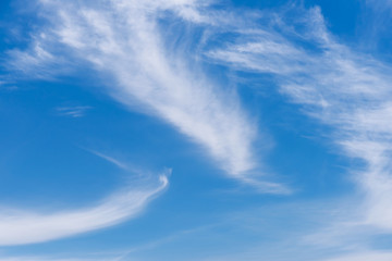 Naklejka na ściany i meble Striped white cirrus clouds in the blue sky. Abstract nature background.