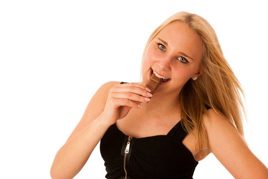 Beautiful young woman eats chocolate isolated over white backgro