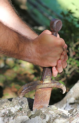 Knight and the famous Excalibur sword in the stone